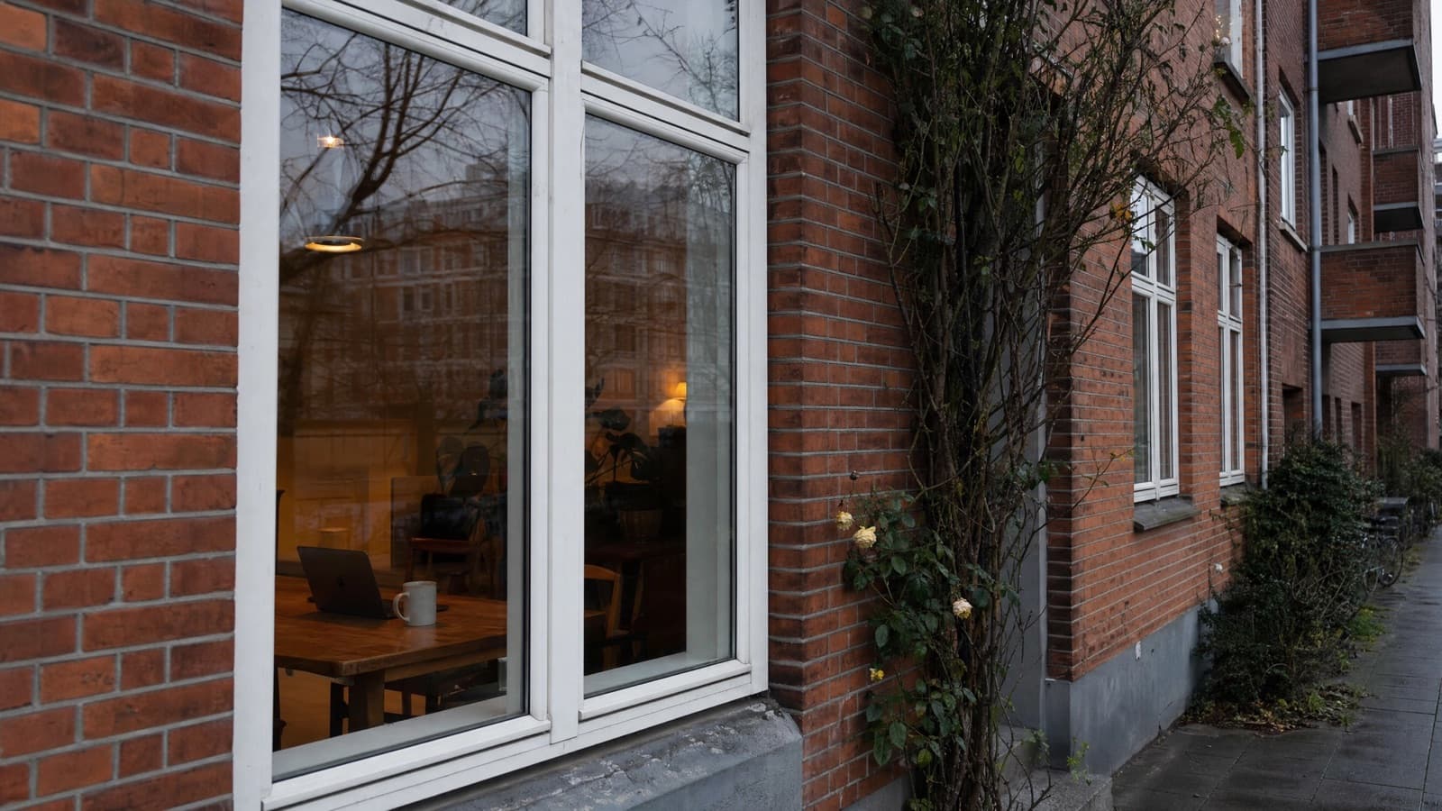 Mand ved laptop i køkken — boligejer tjekker Airbnb-regler i København